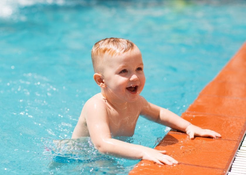 Portrait of happy little boy swimming in pool