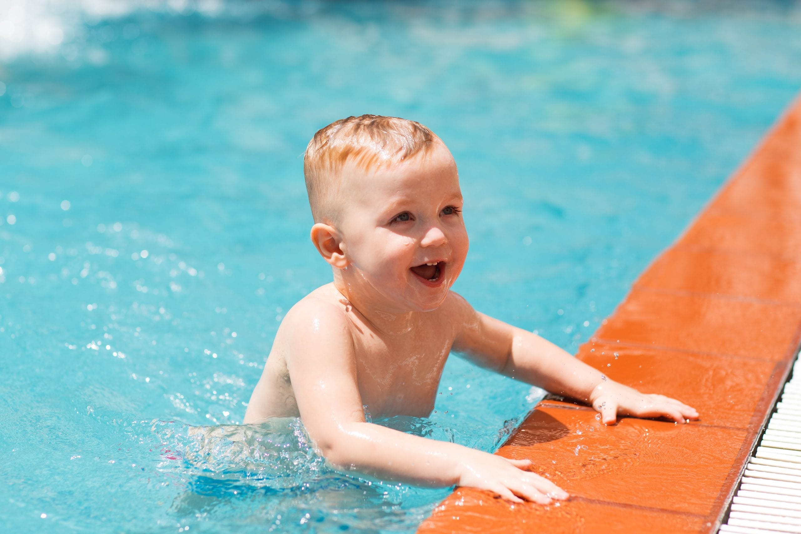Portrait of happy little boy swimming in pool